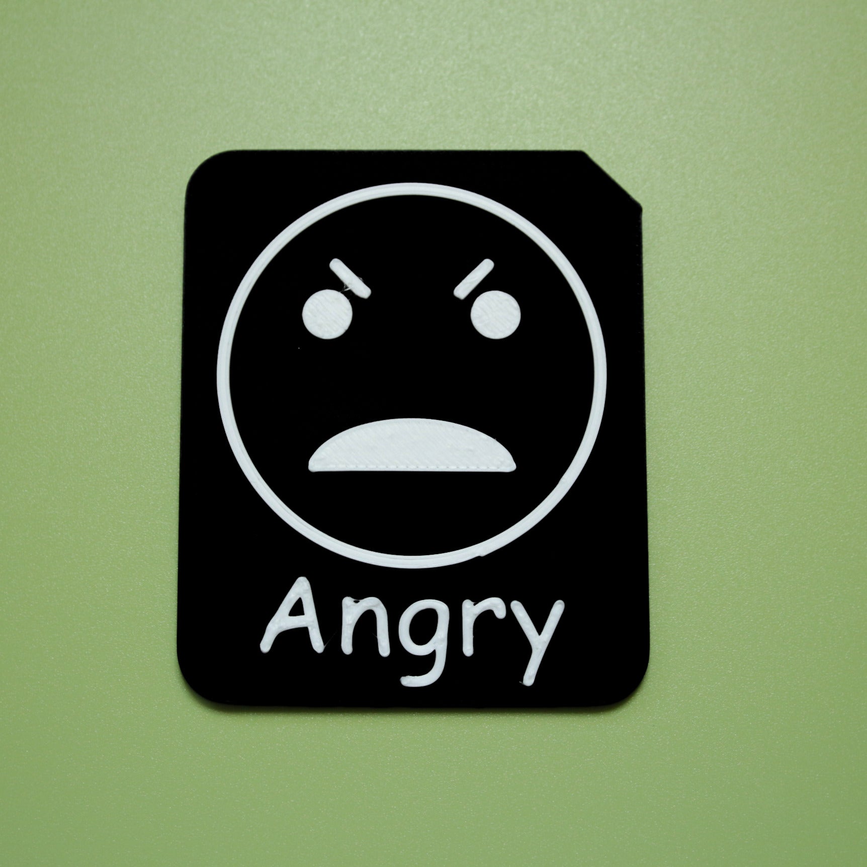 Angry tactile tile - 3D printed raised symbol showing upset face for AAC and SEND communication with vocabulary