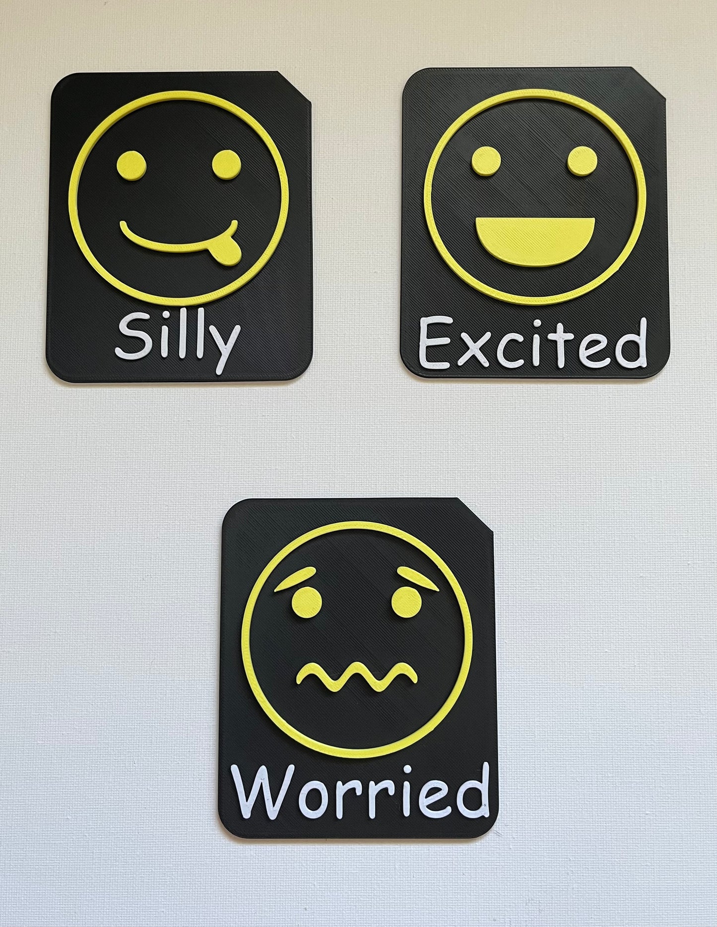 Large format tactile tile showing excited face symbol in yellow Zones of Regulation colour