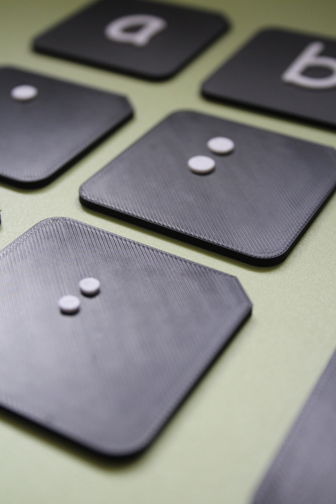 Close up of raised surfaces on braille alphabet tactile tiles showing tactile dot detail for VI and SEND learners
