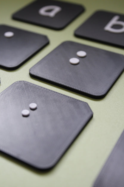 Close up of raised surfaces on braille alphabet tactile tiles showing tactile dot detail for VI and SEND learners