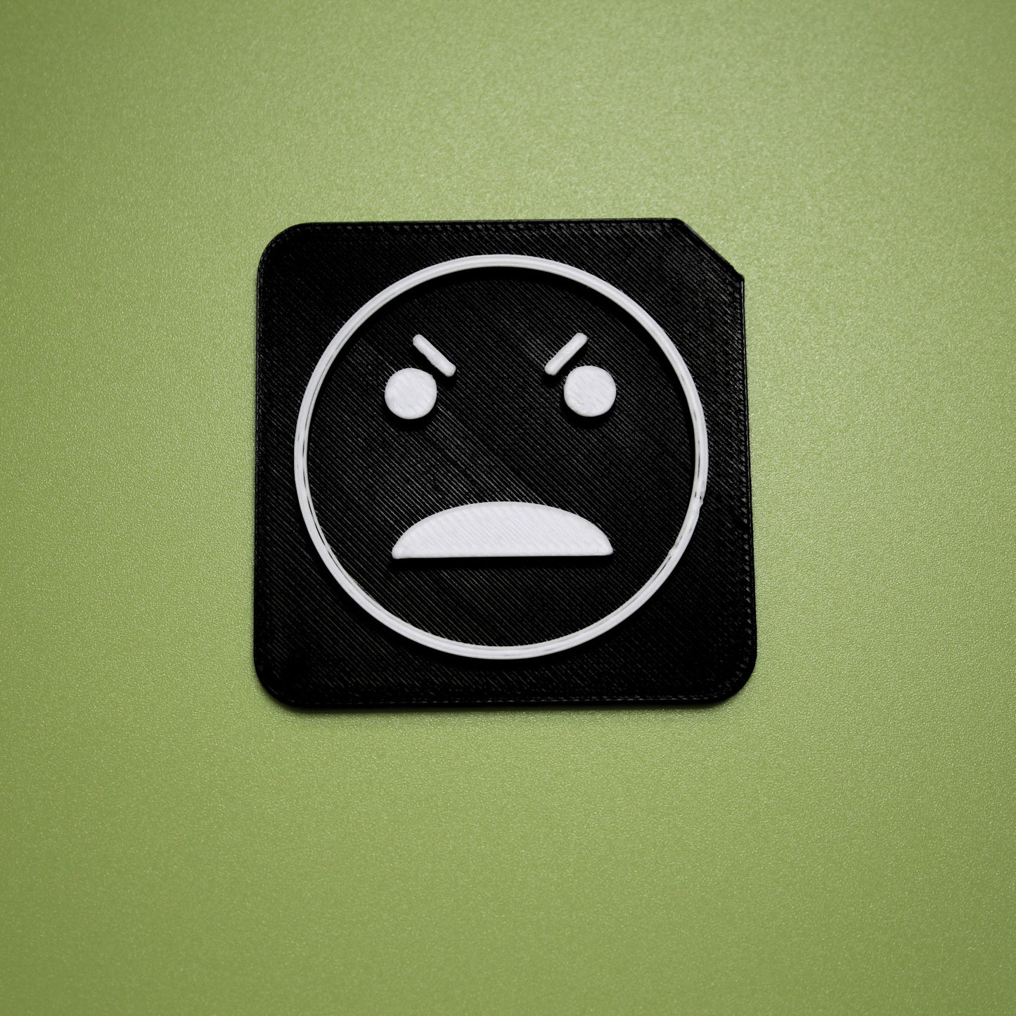 Angry tactile tile - 3D printed raised symbol showing angry face for AAC and SEND communication