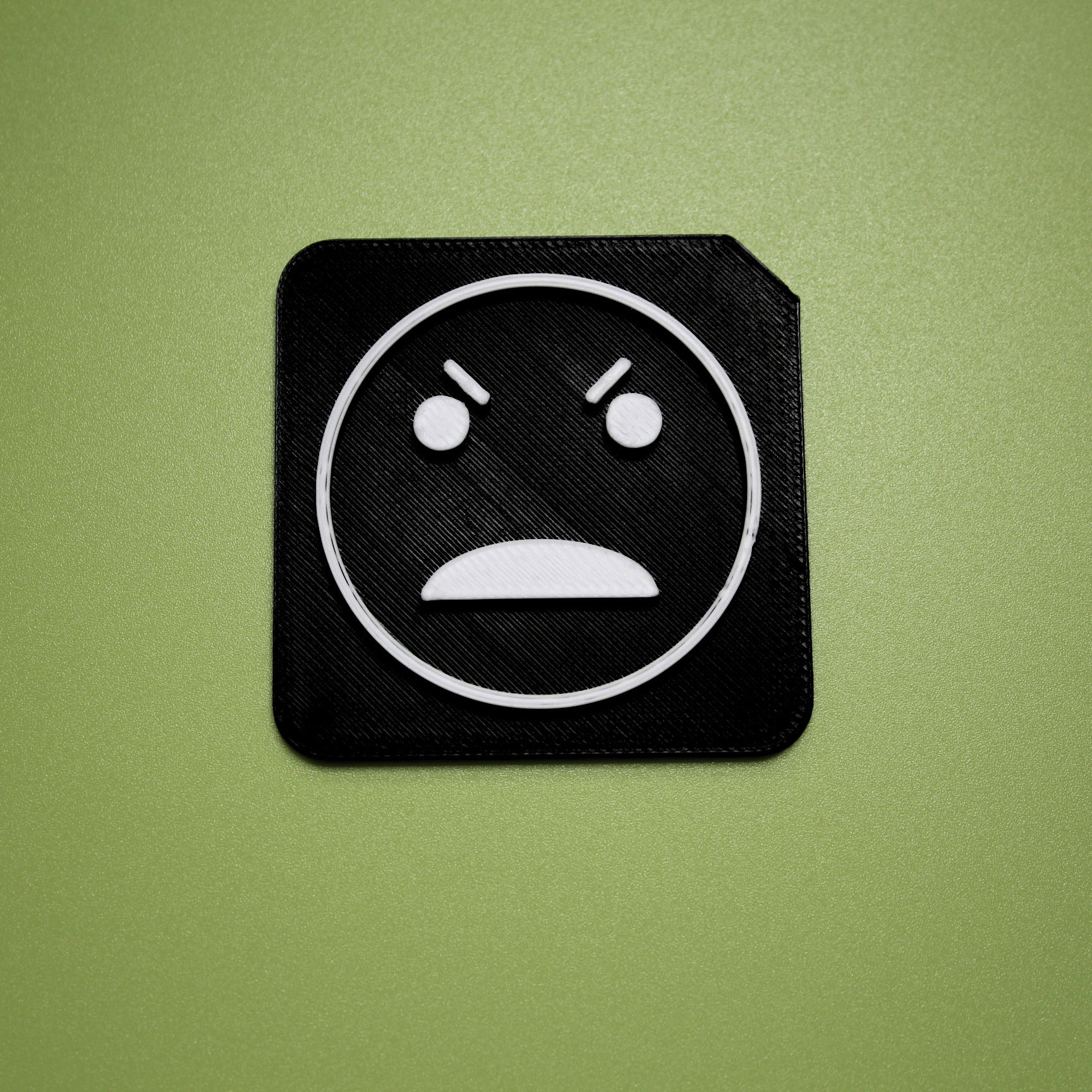 Angry tactile tile - 3D printed raised symbol showing angry face for AAC and SEND communication