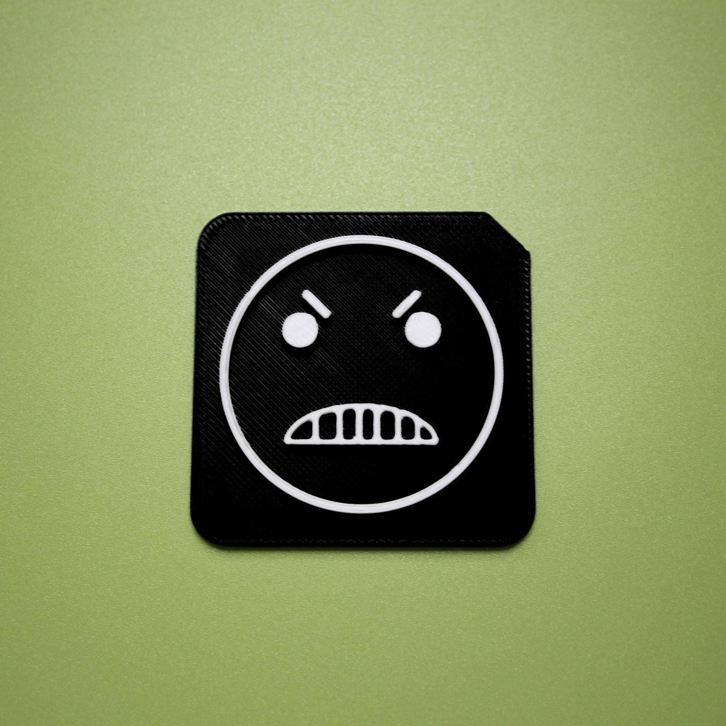 Mean tactile tile - 3D printed raised symbol showing mean face for AAC and SEND communication