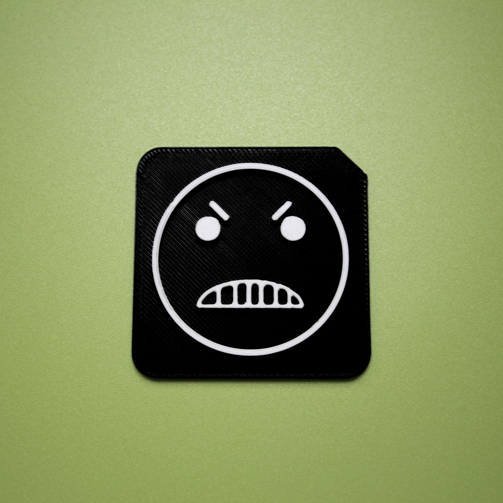 Mean tactile tile - 3D printed raised symbol showing mean face for AAC and SEND communication
