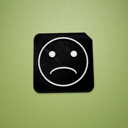 Sad tactile tile - 3D printed raised symbol showing sad face for AAC and SEND communication
