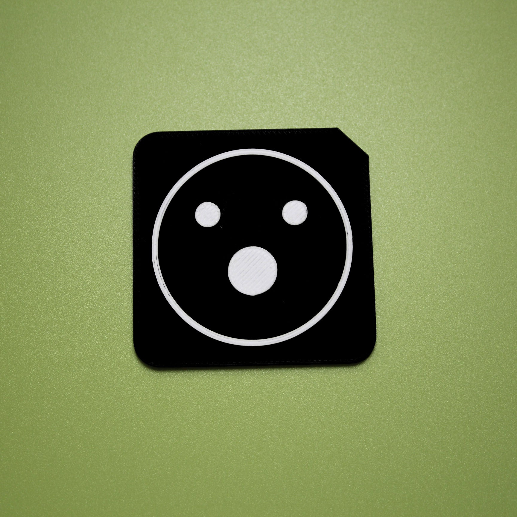 Shocked tactile tile - 3D printed raised symbol showing shocked face for AAC and SEND communication