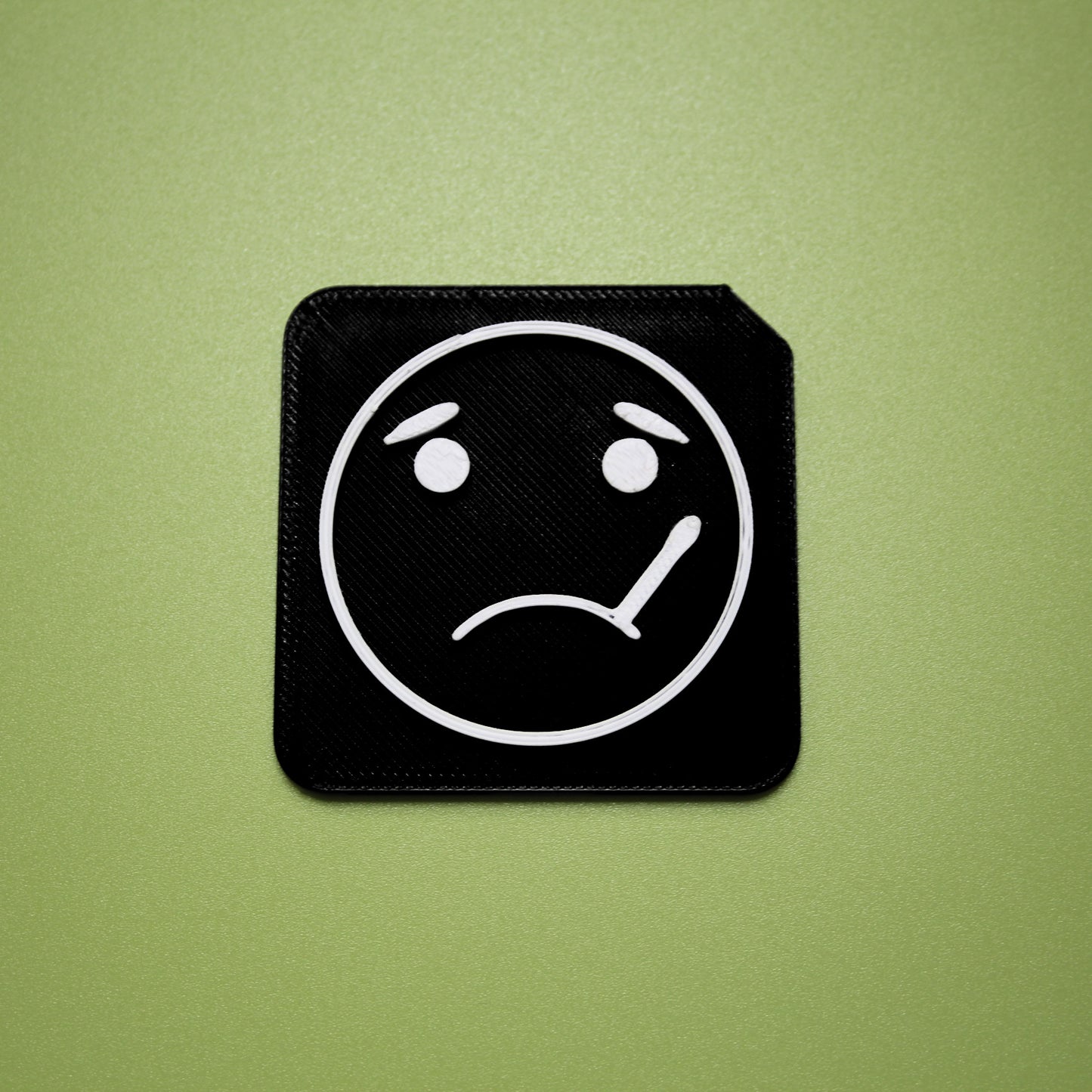 Sick tactile tile - 3D printed raised symbol showing sick face for AAC and SEND communication