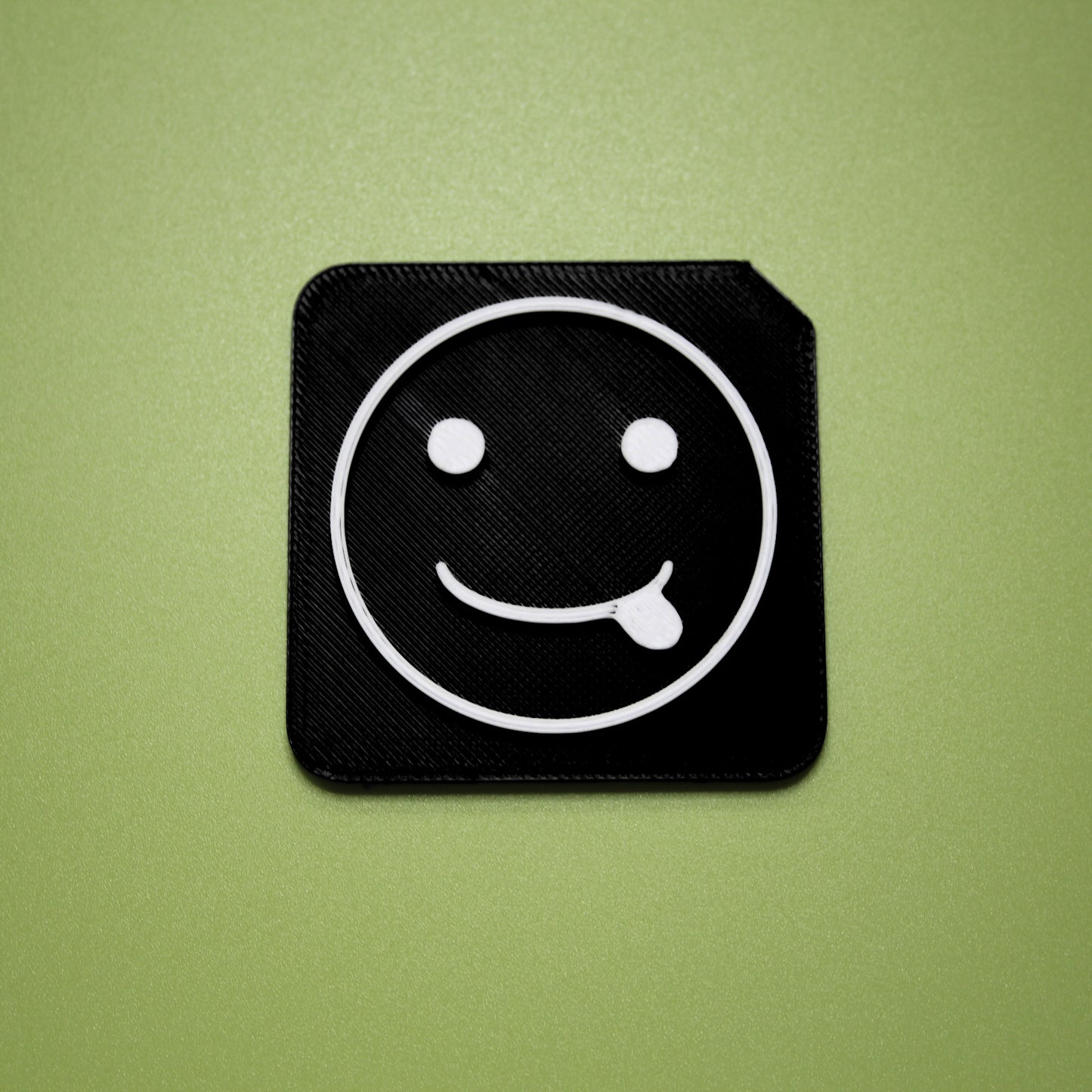 Silly tactile tile - 3D printed raised symbol showing silly face for AAC and SEND communication