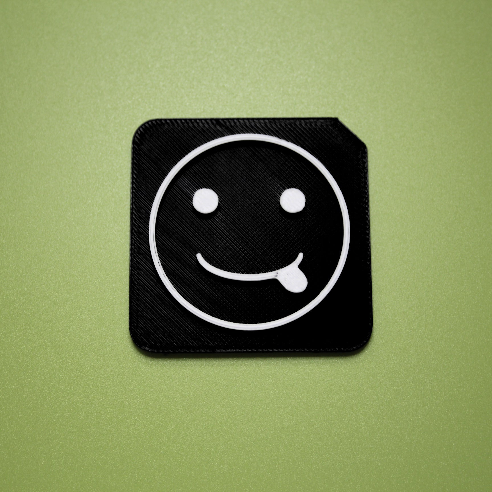 Silly tactile tile - 3D printed raised symbol showing silly face for AAC and SEND communication