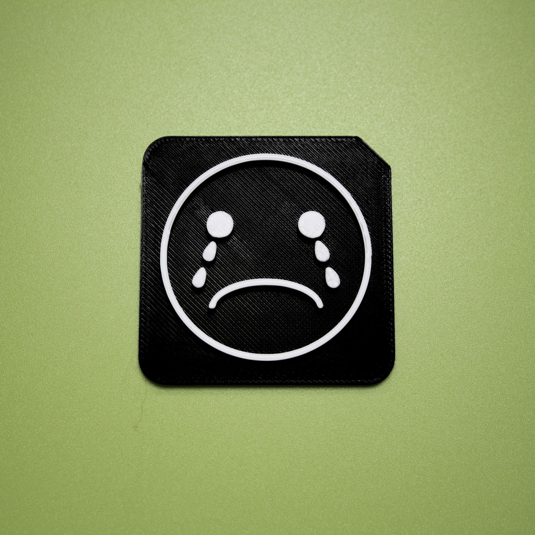 Upset tactile tile - 3D printed raised symbol showing upset face for AAC and SEND communication