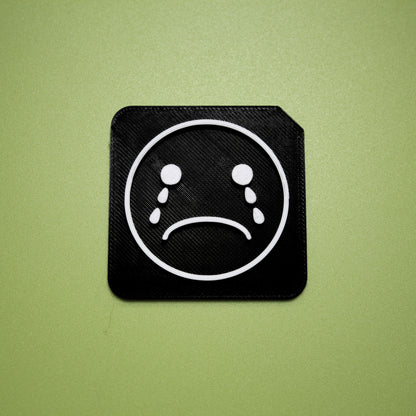 Upset tactile tile - 3D printed raised symbol showing upset face for AAC and SEND communication