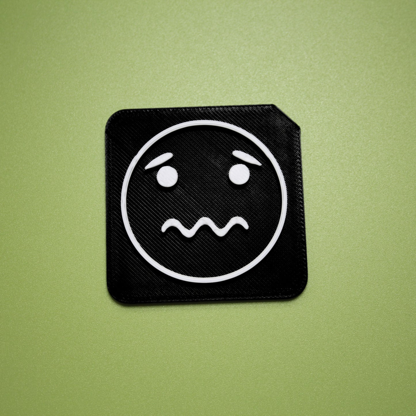 Worried tactile tile - 3D printed raised symbol showing worried face for AAC and SEND communication