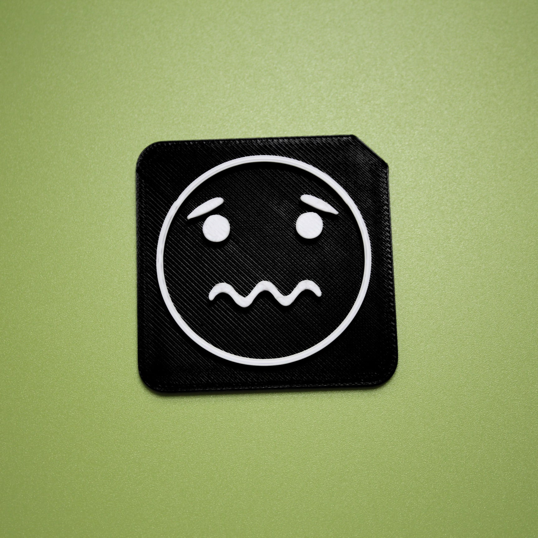 Worried tactile tile - 3D printed raised symbol showing worried face for AAC and SEND communication