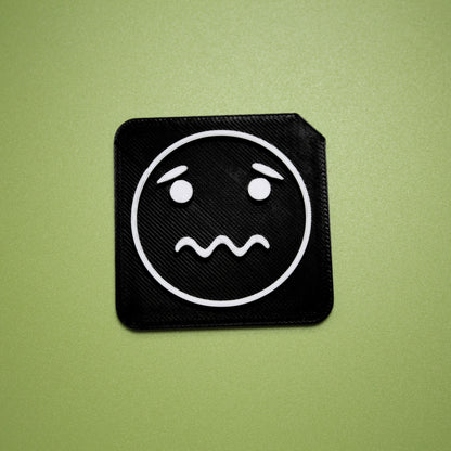 Worried tactile tile - 3D printed raised symbol showing worried face for AAC and SEND communication