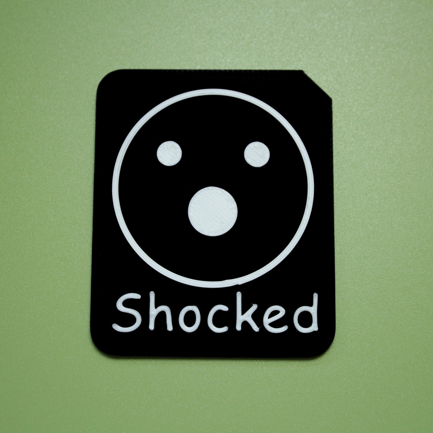 Shocked tactile tile - 3D printed raised symbol showing proud face for AAC and SEND communication with vocabulary