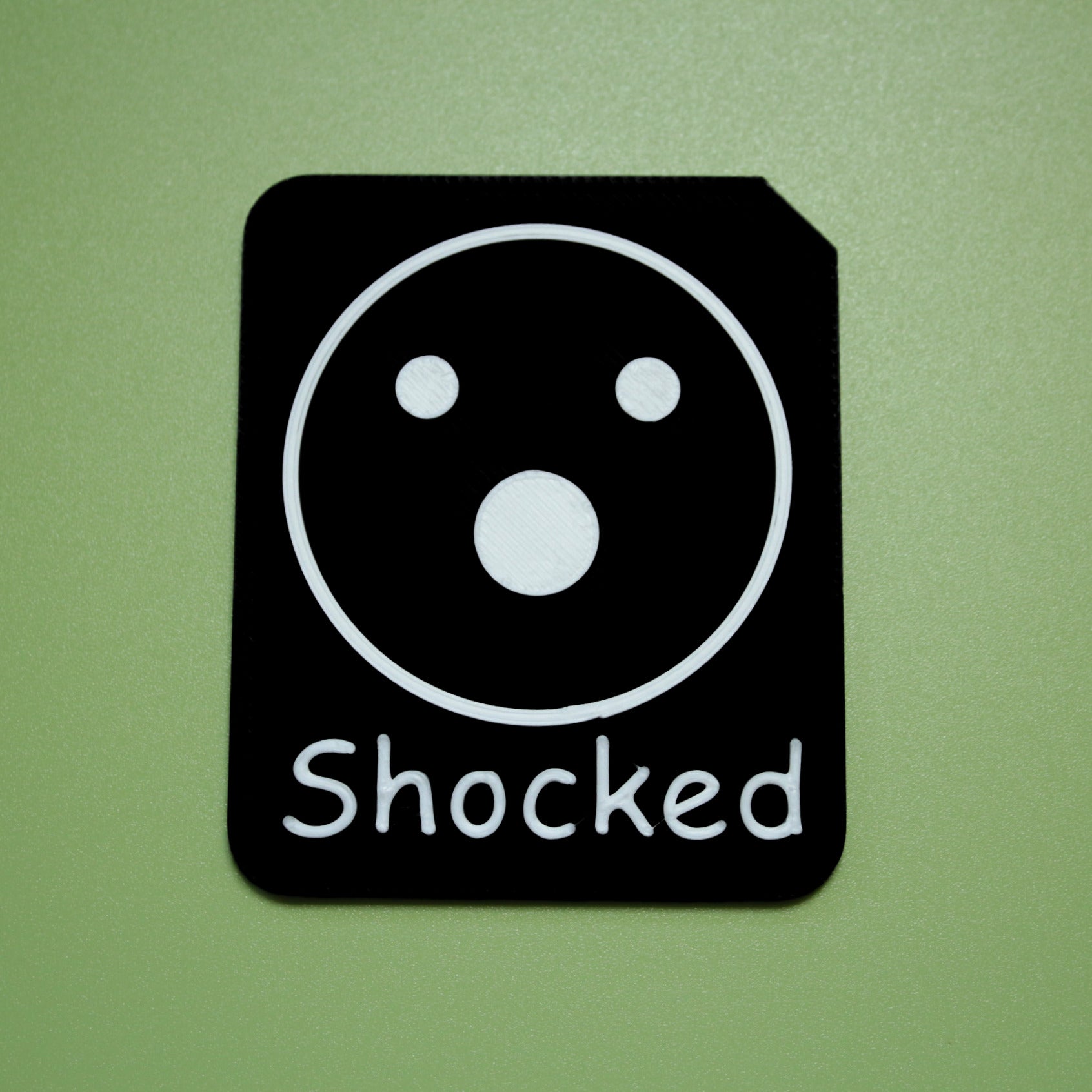 Shocked tactile tile - 3D printed raised symbol showing proud face for AAC and SEND communication with vocabulary